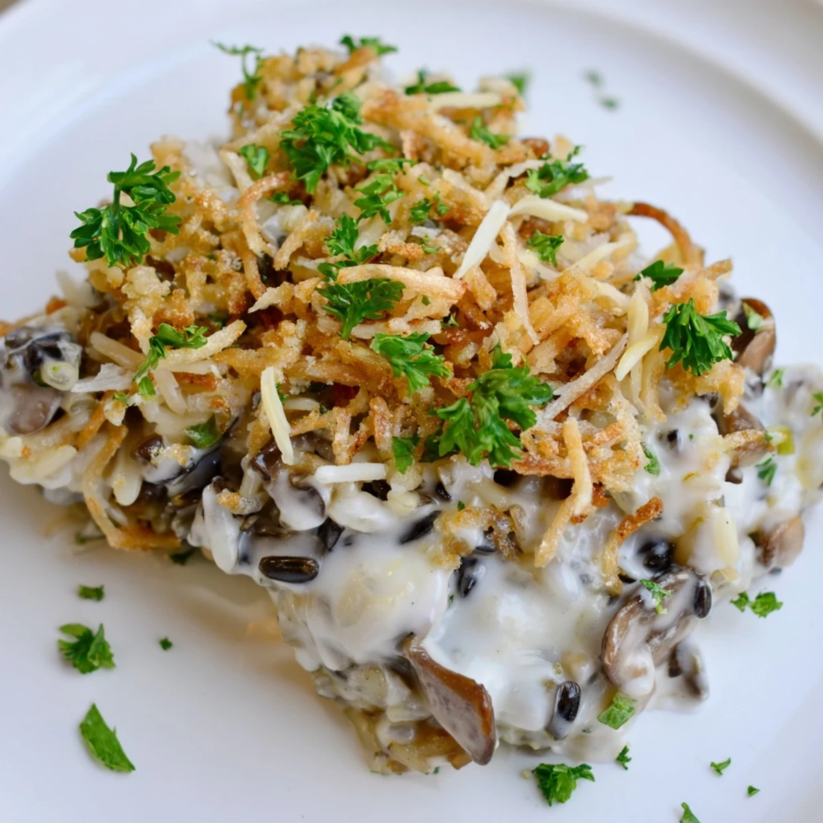 Golden-brown Creamy Mushroom and Wild Rice Casserole bubbling in a dish, topped with crispy panko and fresh parsley.