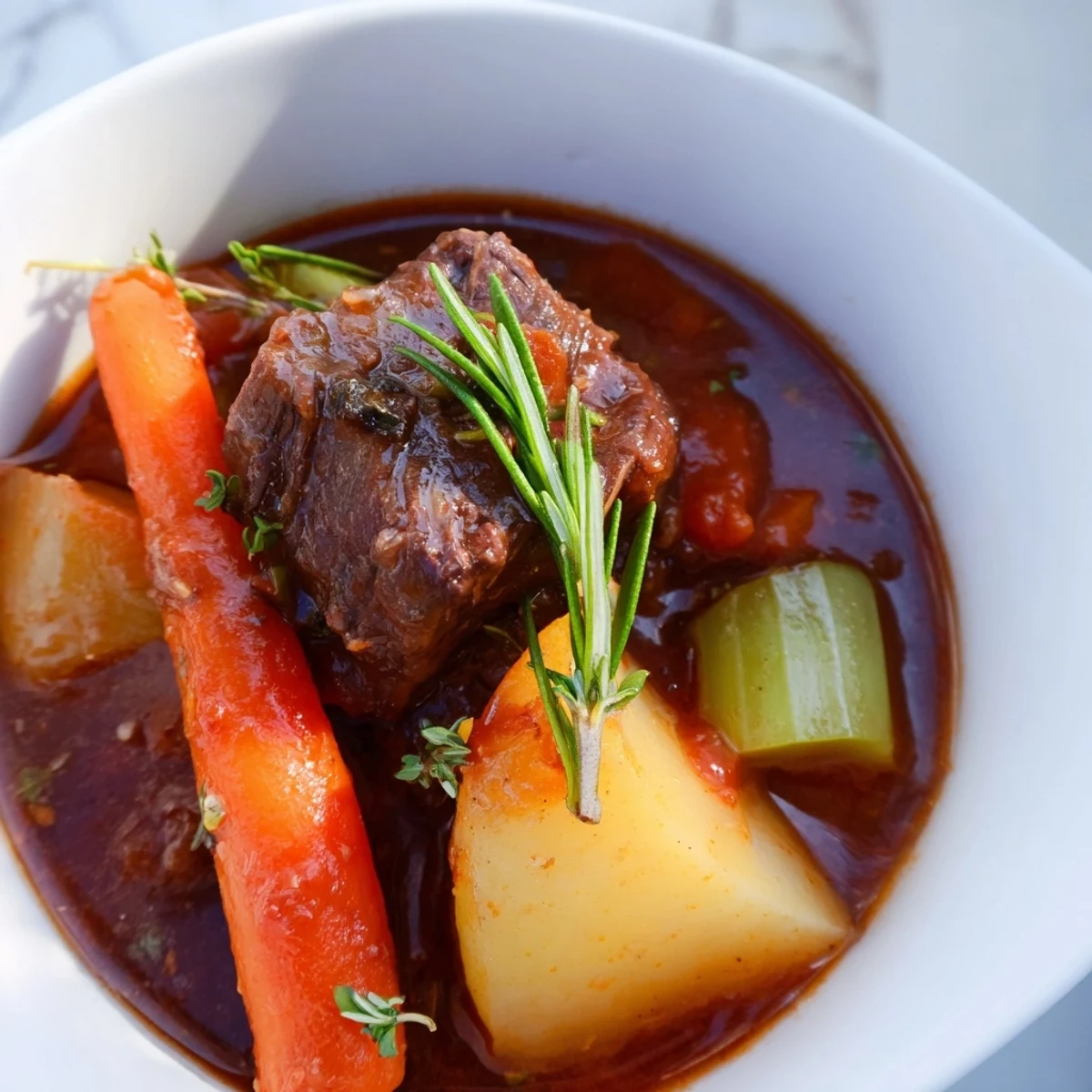Rustic, gluten-free Savory Lamb Stew with Potatoes in a Dutch oven, garnished with fresh herbs and peas.