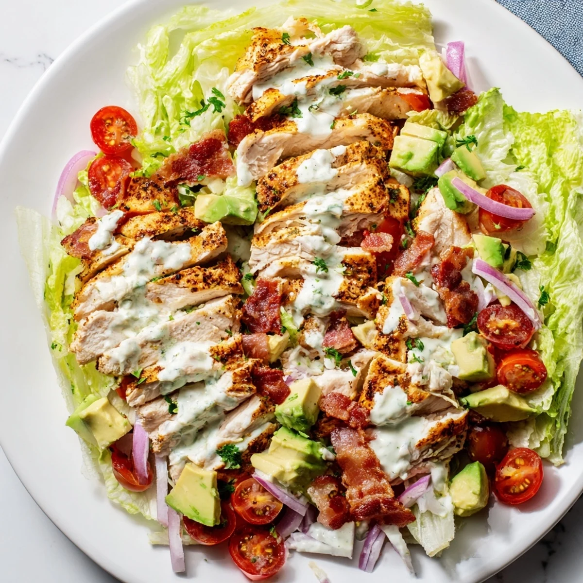 Creamy BLT Chicken Salad with juicy grilled chicken, crispy bacon, and ripe cherry tomatoes in a bowl.