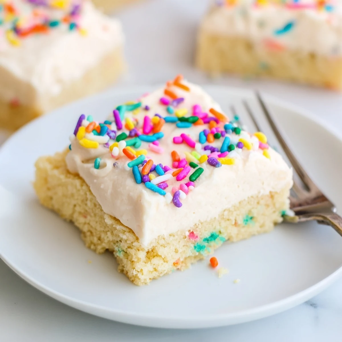A close-up of frosted Sugar Cookie Bars showing soft edges, melted butter, and colorful toppings.