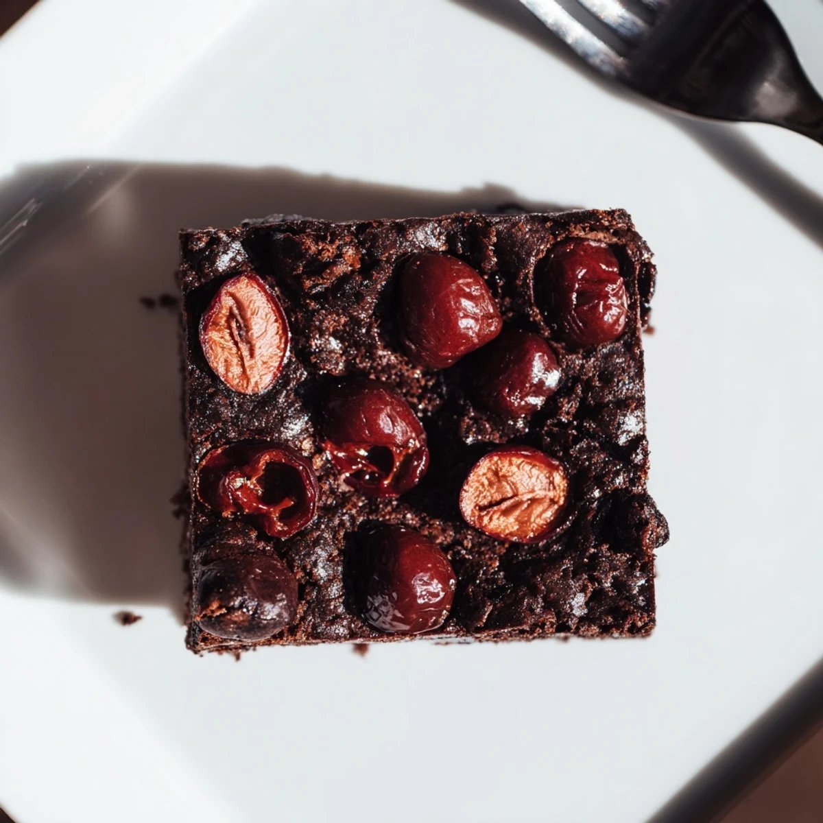 Decadent chocolate Roasted Cherry Brownies served à la mode with vanilla ice cream melting on top.
