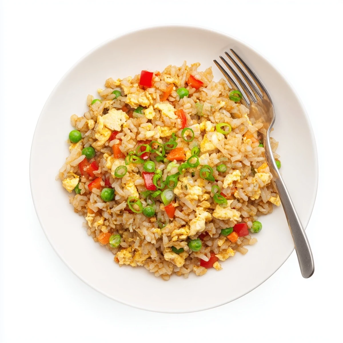 Fried rice with fluffy grains, vibrant peas, carrots, and scrambled eggs in a hot wok.