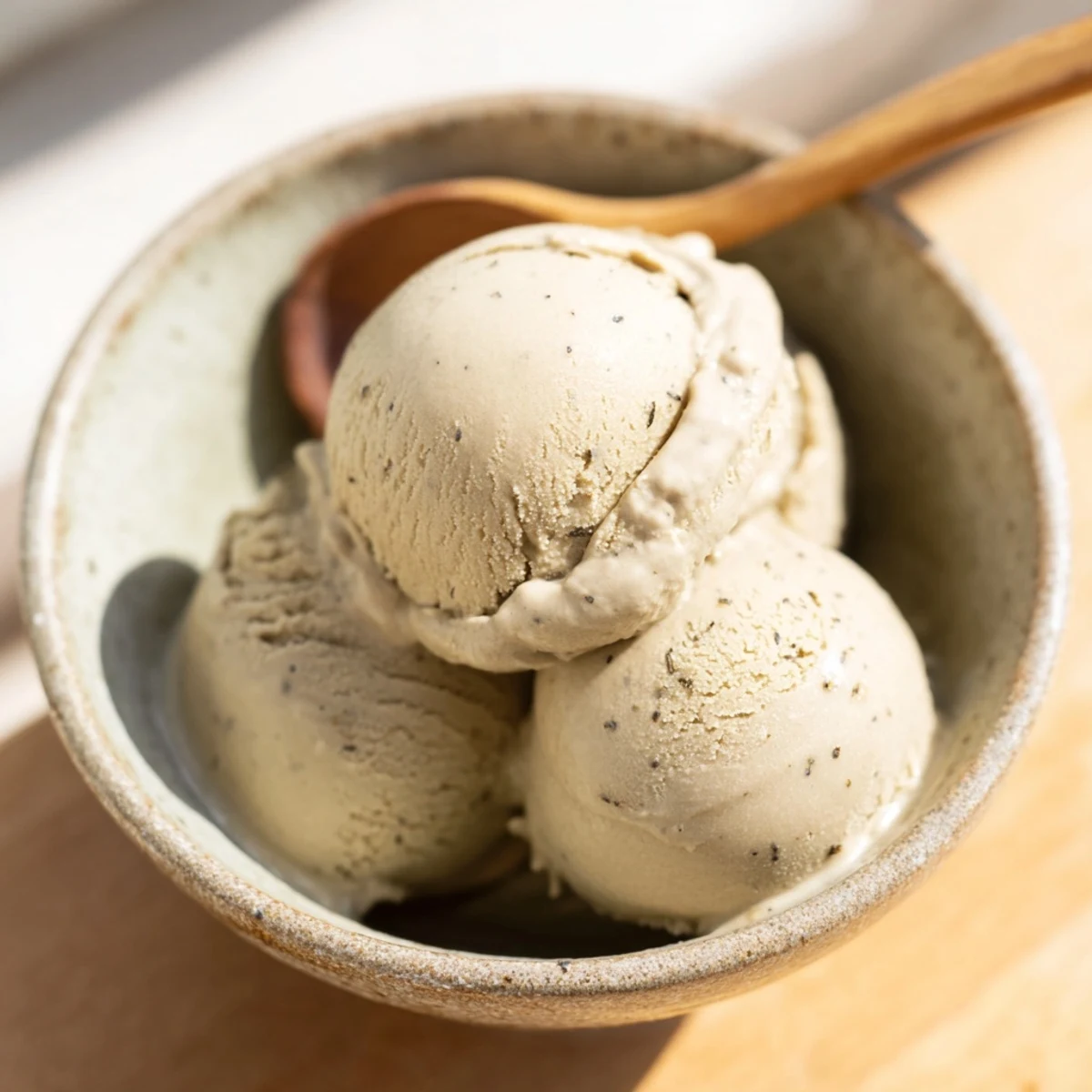 Creamy scoops of homemade Hojicha Ice Cream served in a chilled bowl with a toasted sesame garnish.