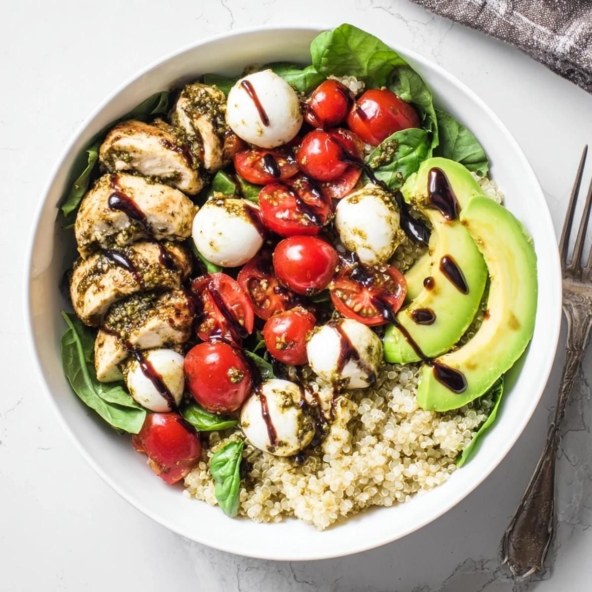 A vibrant Pesto Chicken Caprese Grain Bowl with juicy grilled chicken, fresh mozzarella, and tomatoes.