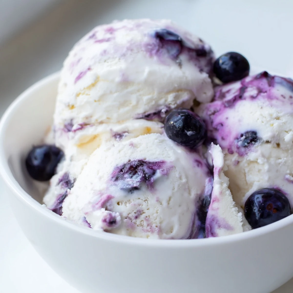 Blueberry Cottage Cheese Ice Cream is shown in a loaf pan, swirled with blueberry compote and a touch of honey, perfect for easy no-churn homemade treats.