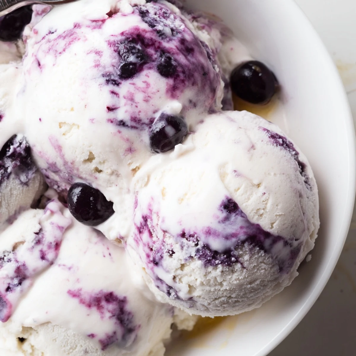 A close-up of Blueberry Cottage Cheese Ice Cream in a cone highlights the creamy texture and vibrant blueberries, ideal for a high-protein vegetarian snack.