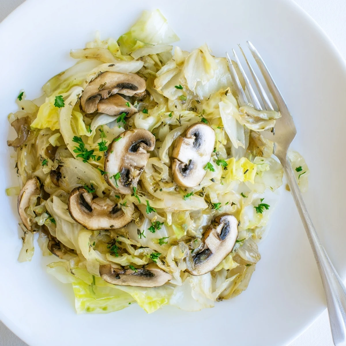 Freshly sautéed Vegetarian Cabbage Mushroom Sauté with tender green cabbage and browned cremini mushrooms in a skillet.