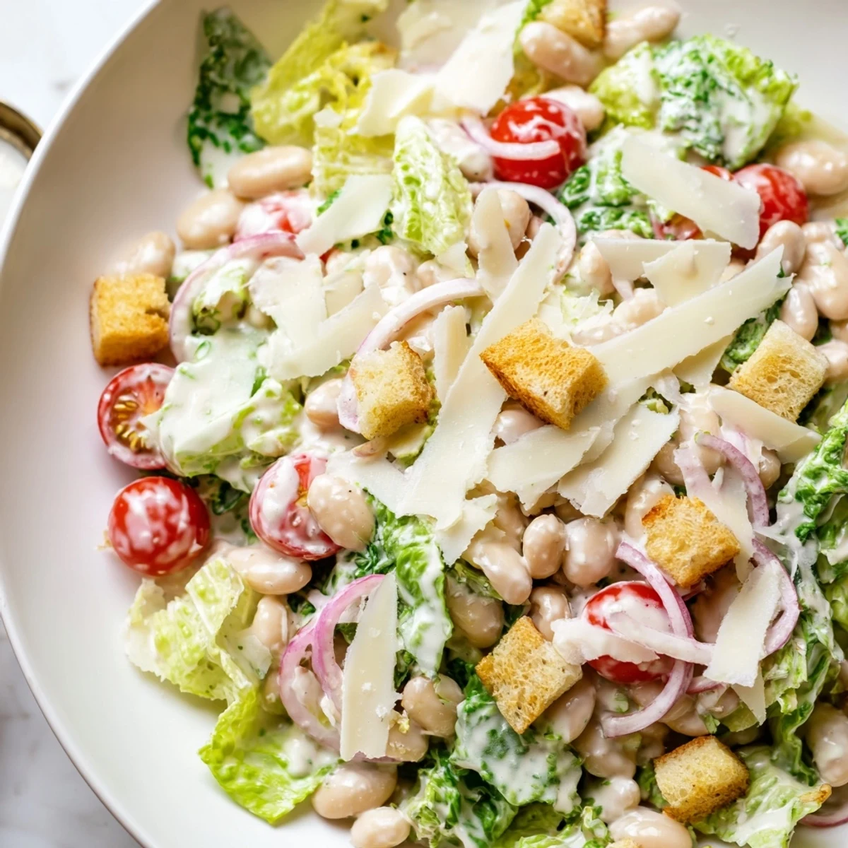 Fresh butter bean Caesar salad with crisp romaine, creamy dressing, and shaved Parmesan