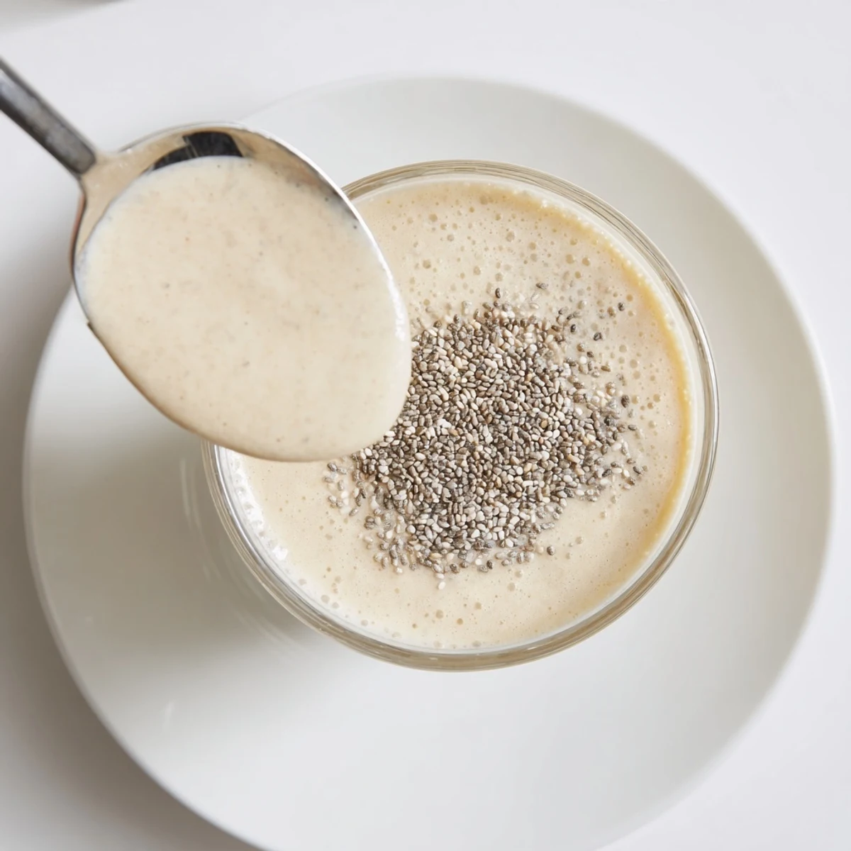 Creamy Greek yogurt banana smoothie poured into a tall glass with sliced banana garnish