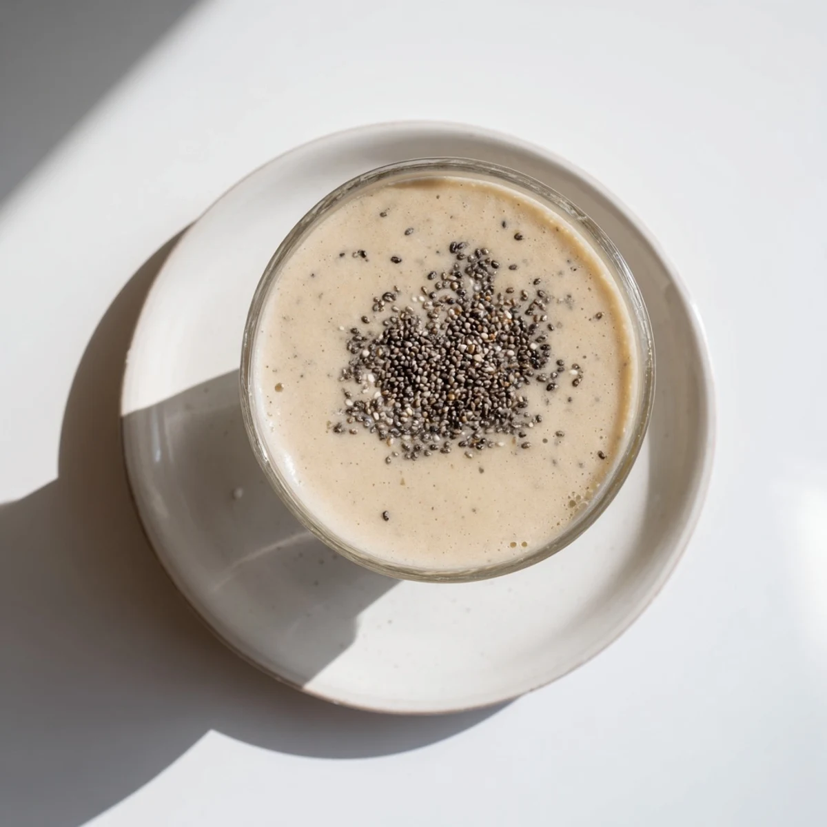 Golden Greek yogurt banana smoothie topped with fresh banana slices and a sprinkle of cinnamon