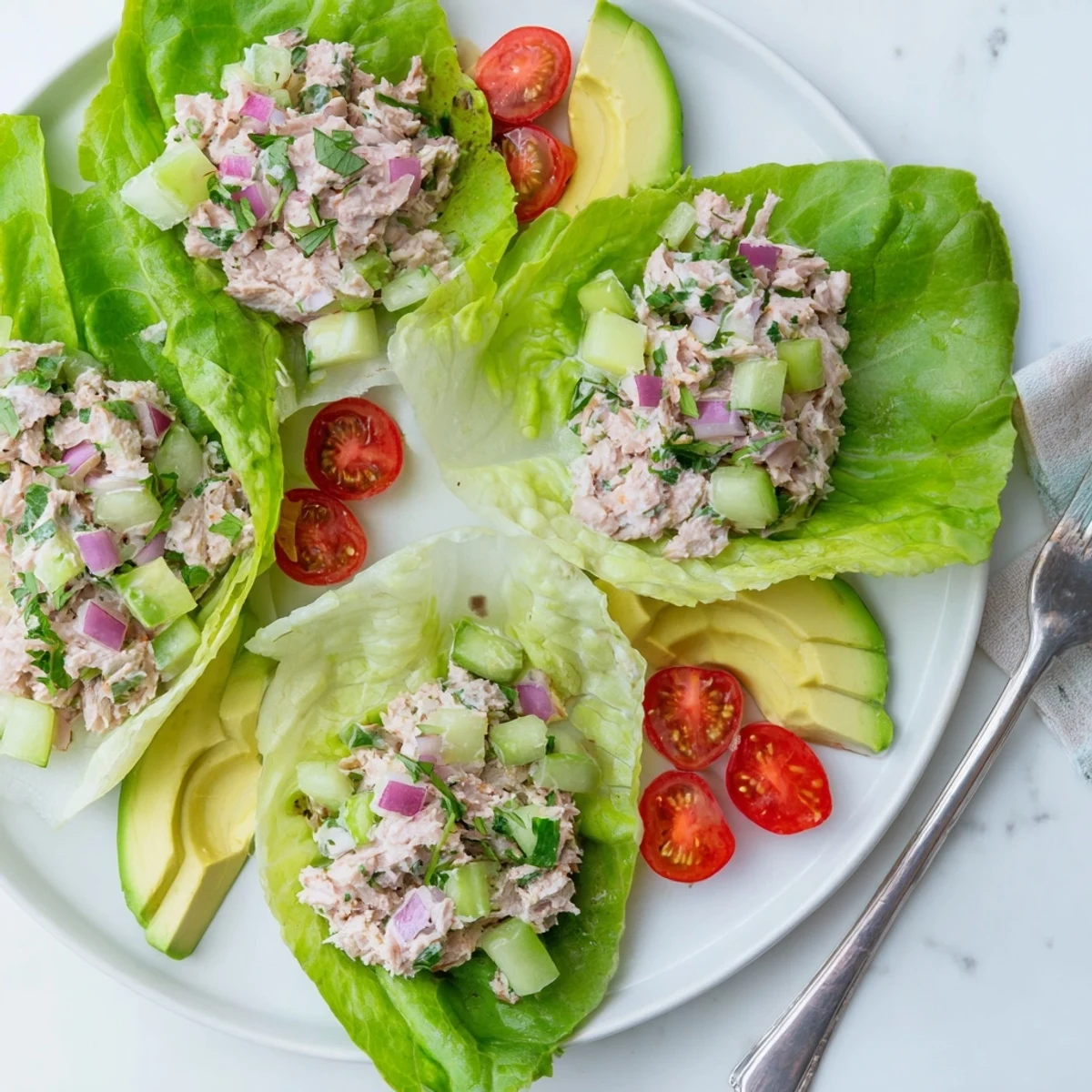 Creamy tuna salad piled in crisp butter lettuce cups with fresh avocado slices