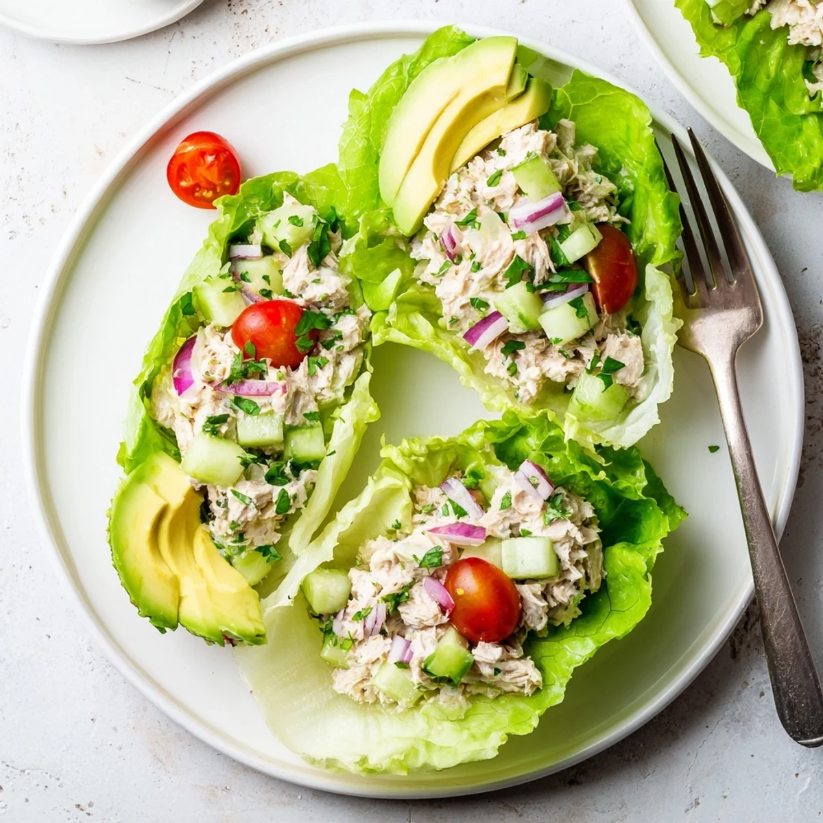 Protein-rich tuna salad nestled in romaine leaves with cucumber and red onion crunch