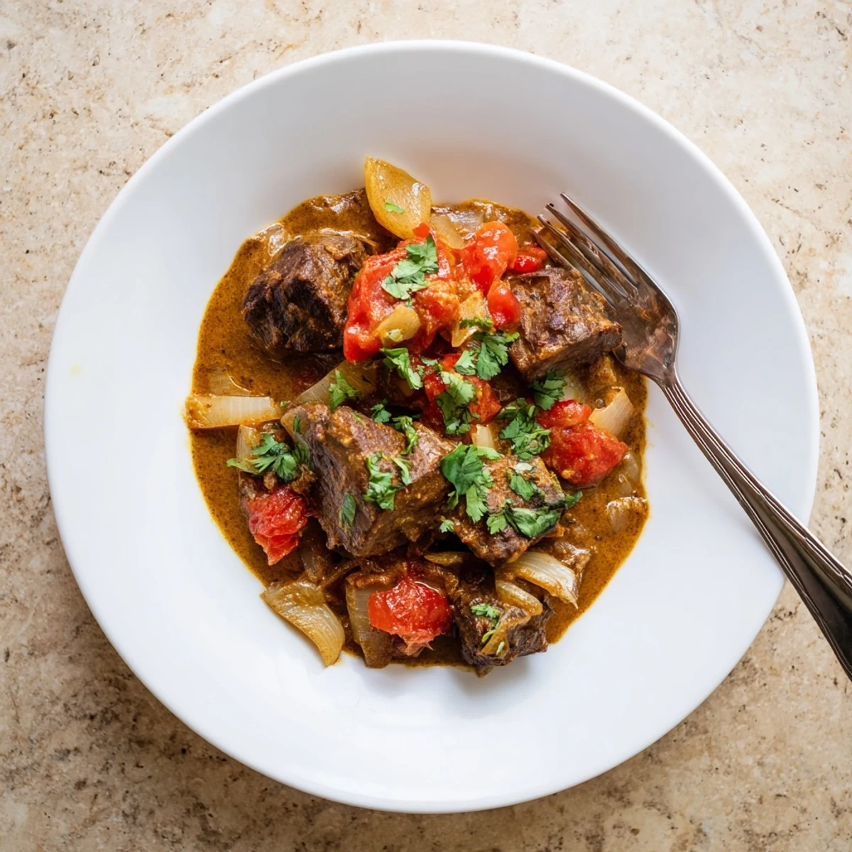 Tender beef chunks simmered in aromatic Indian beef curry with golden sauce and fresh cilantro garnish