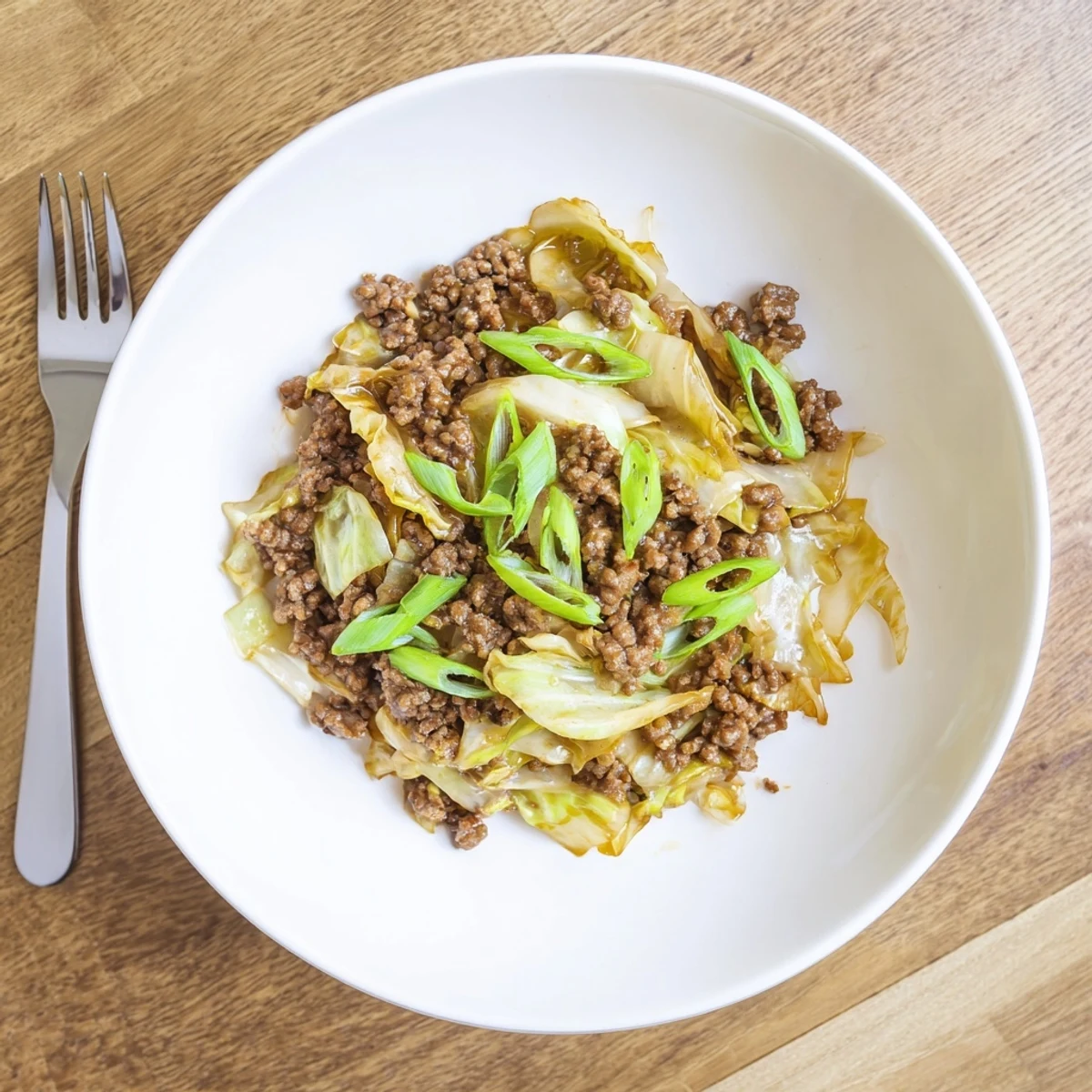 Savory skillet of Mongolian ground beef and cabbage stir fry glistening with sesame soy sauce