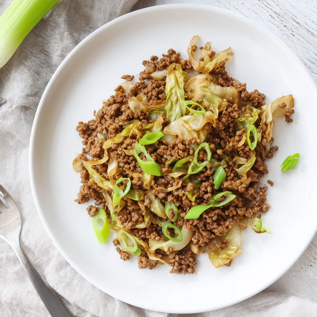Close up of low carb Mongolian ground beef mixed with crisp cabbage in a dark pan