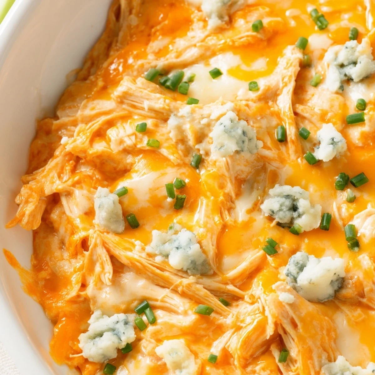Creamy crockpot buffalo chicken dip bubbling with melted cheddar and mozzarella cheese