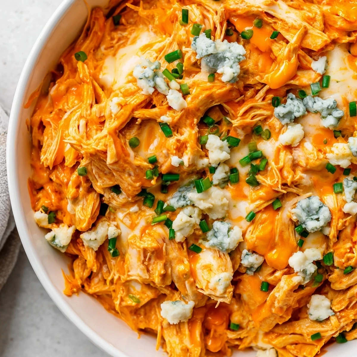 Slow cooker buffalo chicken dip topped with fresh chives and crumbled blue cheese