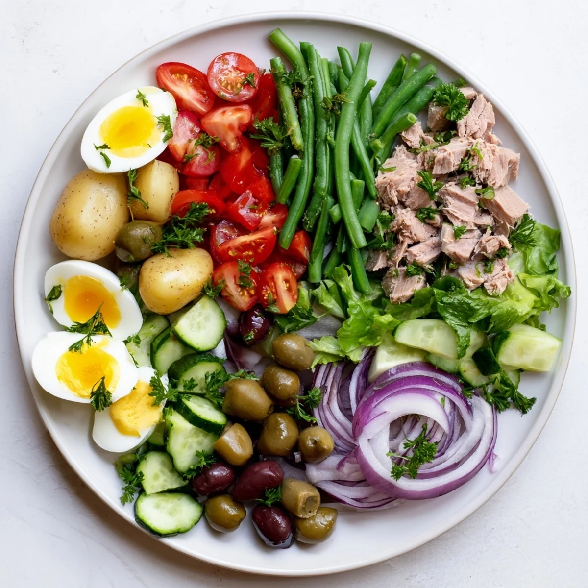 Vibrant French Niçoise Salad featuring tender potatoes, green beans, cherry tomatoes, and flaky tuna on fresh lettuce