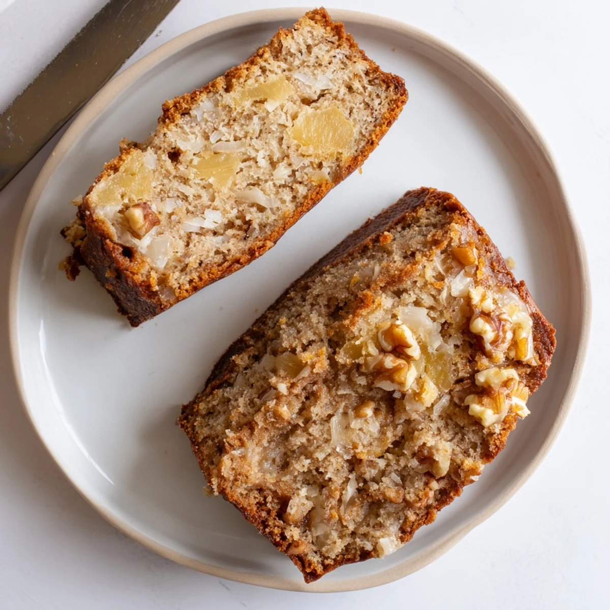 Freshly baked coconut pineapple banana bread cooling on wire rack with golden crust and fluffy interior visible