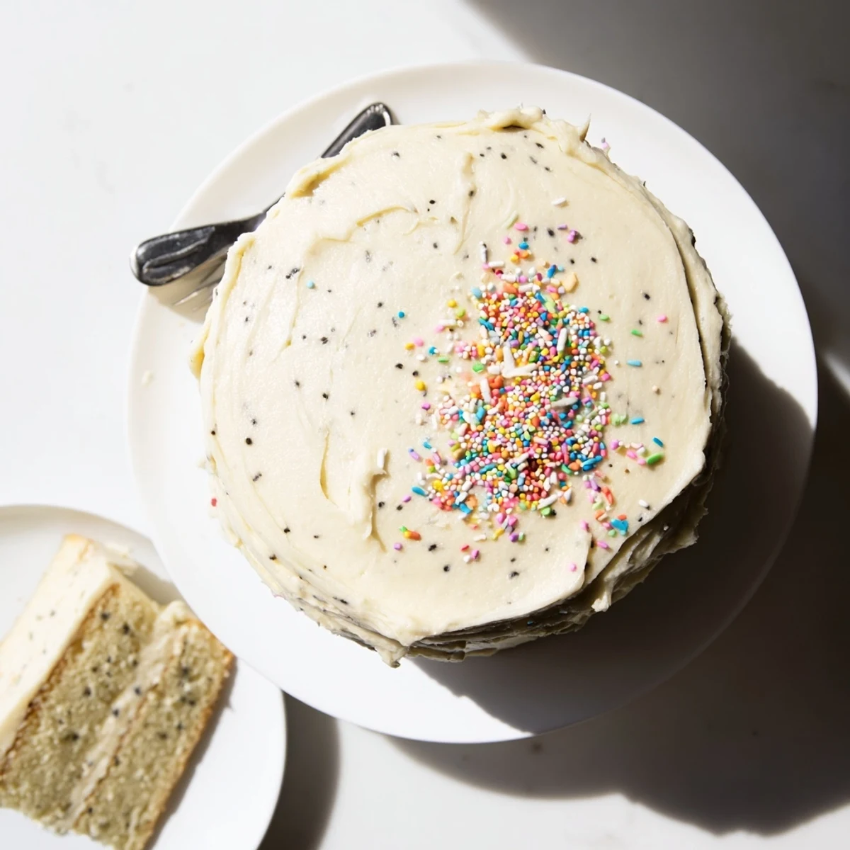 Golden vanilla bean birthday cake layered with silky buttercream frosting and topped with colorful sprinkles