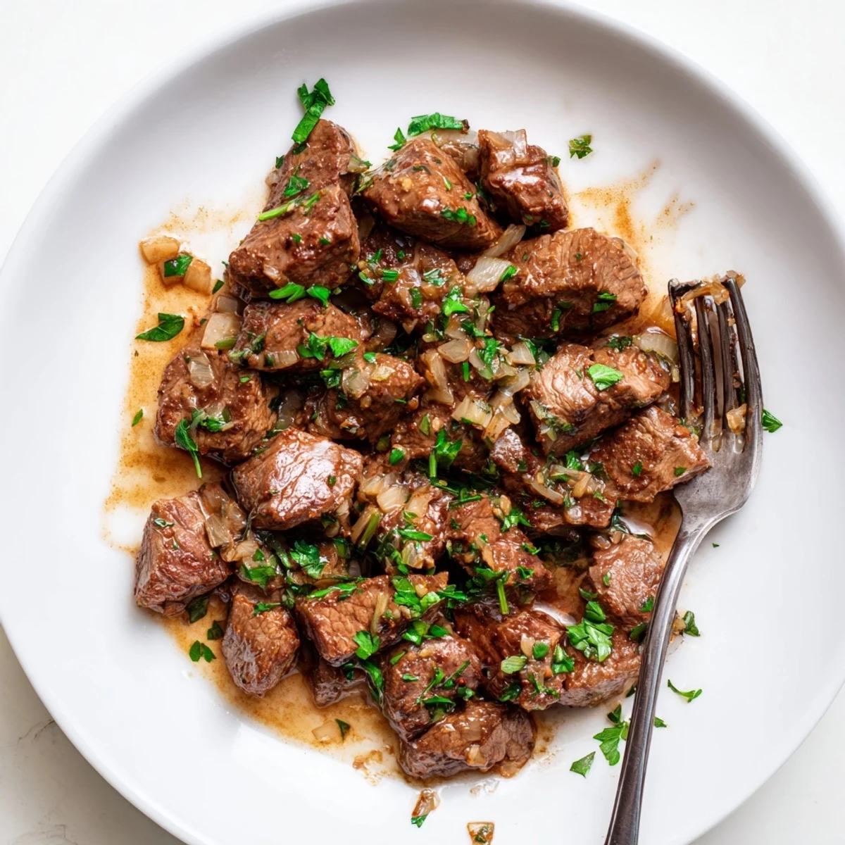 Succulent slow-cooked steak bites in rich beef broth with melted butter and herbs