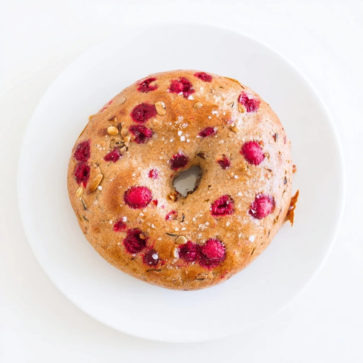 Homemade raspberry sourdough bagels sliced open revealing chewy texture and fruit pockets