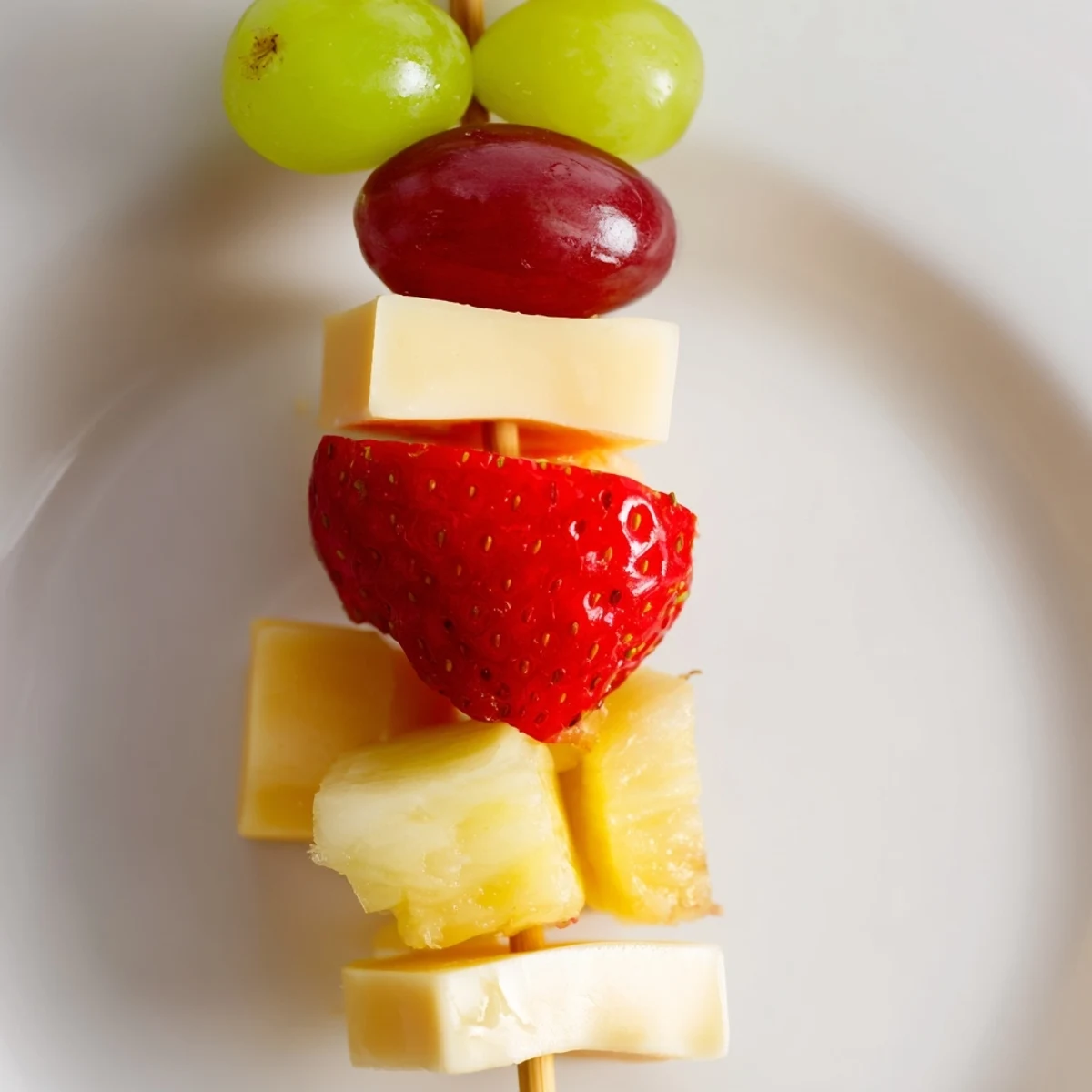 Fresh fruit and cheese kabobs featuring alternating grapes, berries, and creamy Monterey Jack on wooden skewers