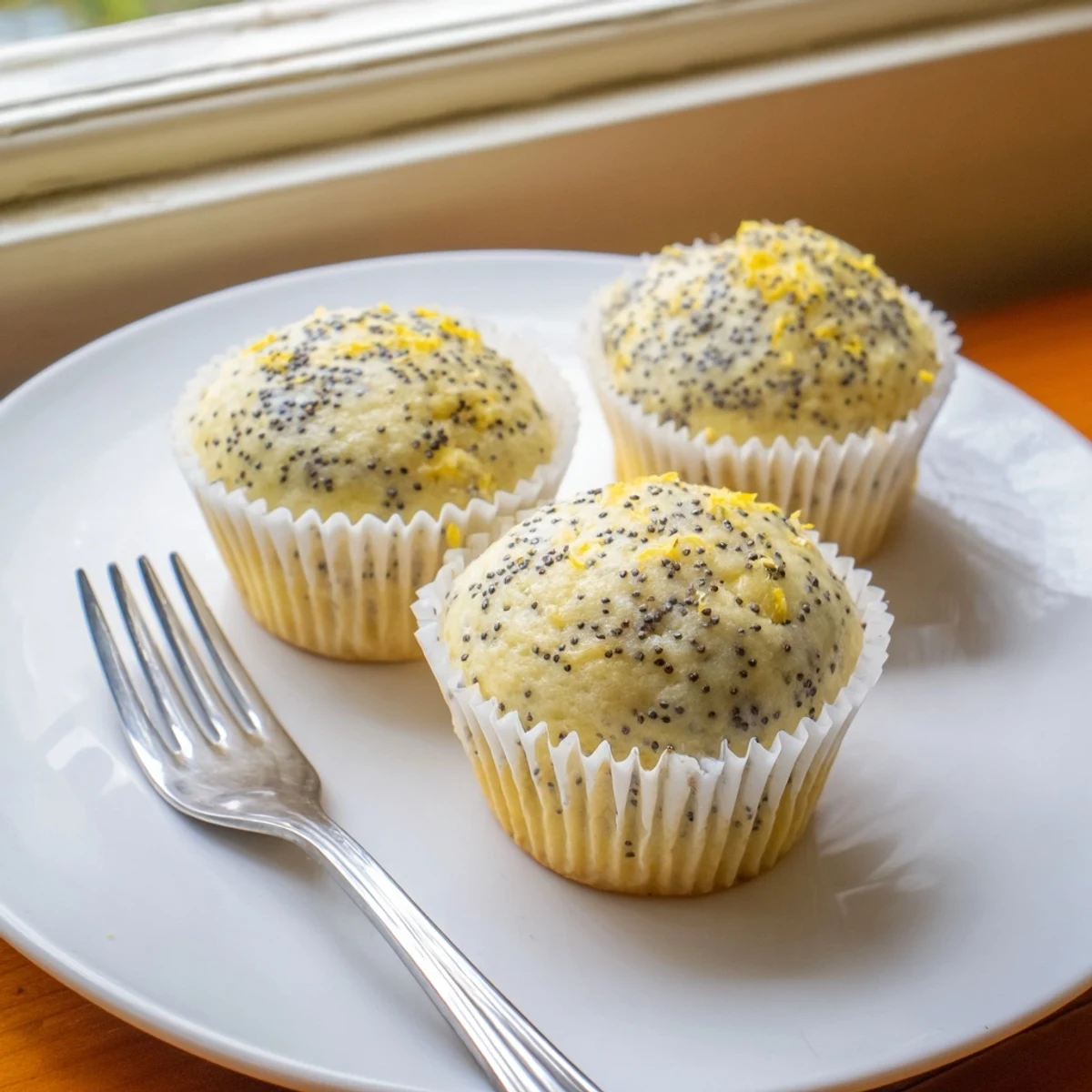 Golden lemon poppy seed muffins with domed tops fresh from the oven on a wire cooling rack