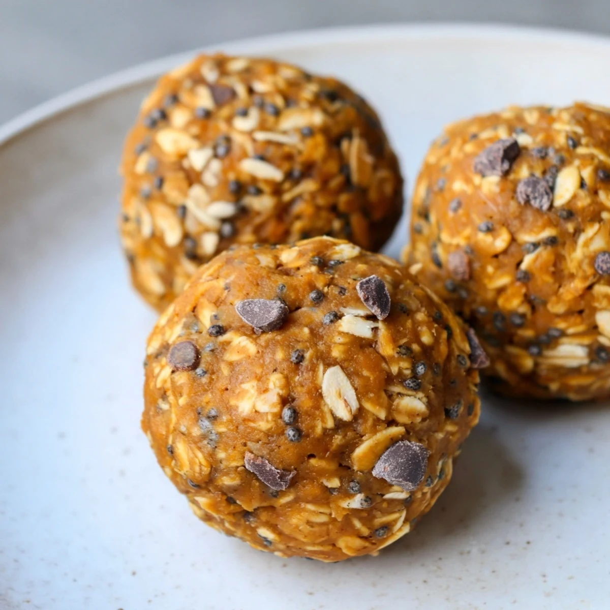 Plump no bake pumpkin protein balls studded with chocolate chips and chopped pecans