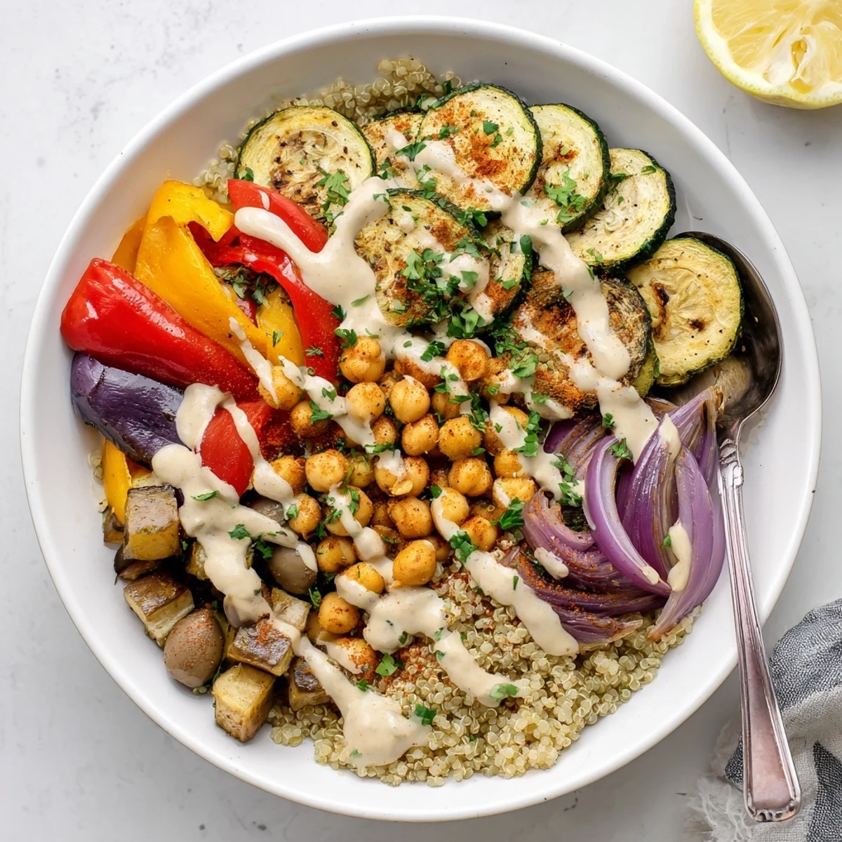Golden roasted zucchini, eggplant, and chickpeas in a vegan Mediterranean bowl drizzled with creamy tahini dressing.