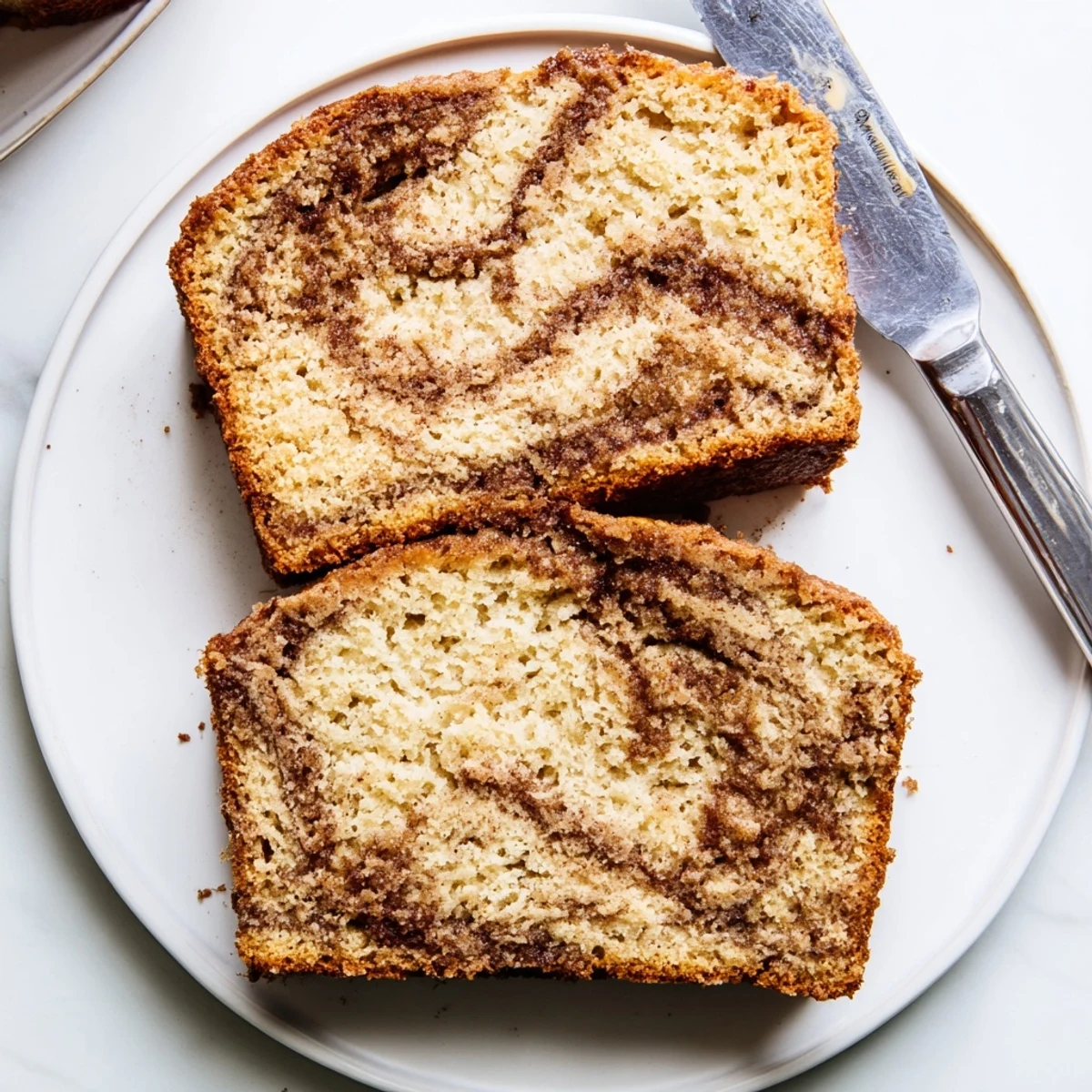 Warm snickerdoodle banana bread loaf freshly baked, topped with a crackled cinnamon sugar crust.