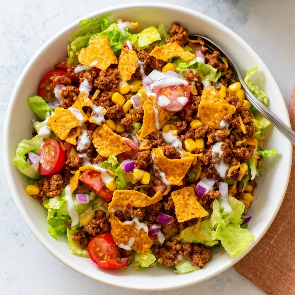 Piled high in a bowl, Simple Doritos Taco Salad with melting cheddar