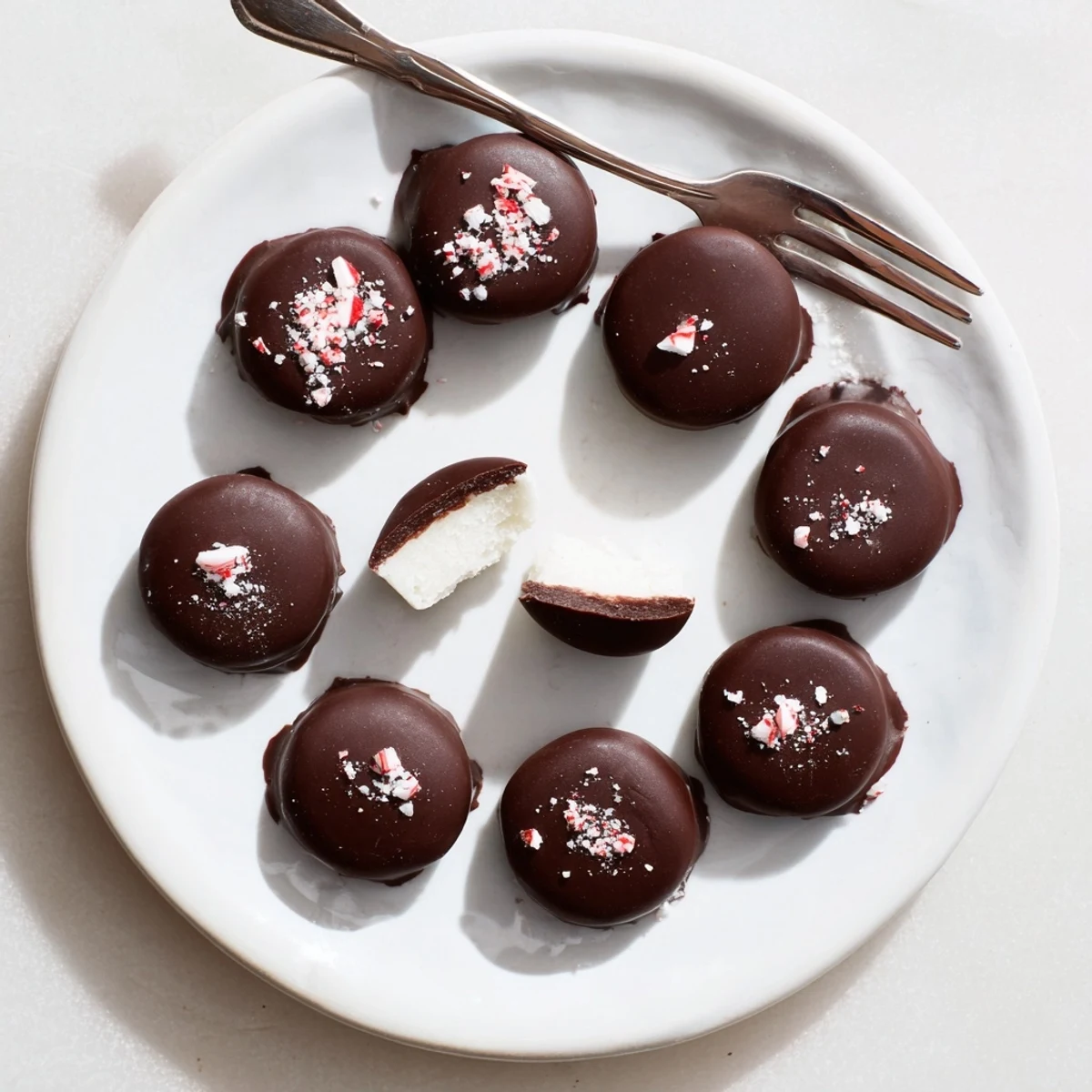 Homemade Peppermint Patties chilled on tray, sprinkled with crushed candy.