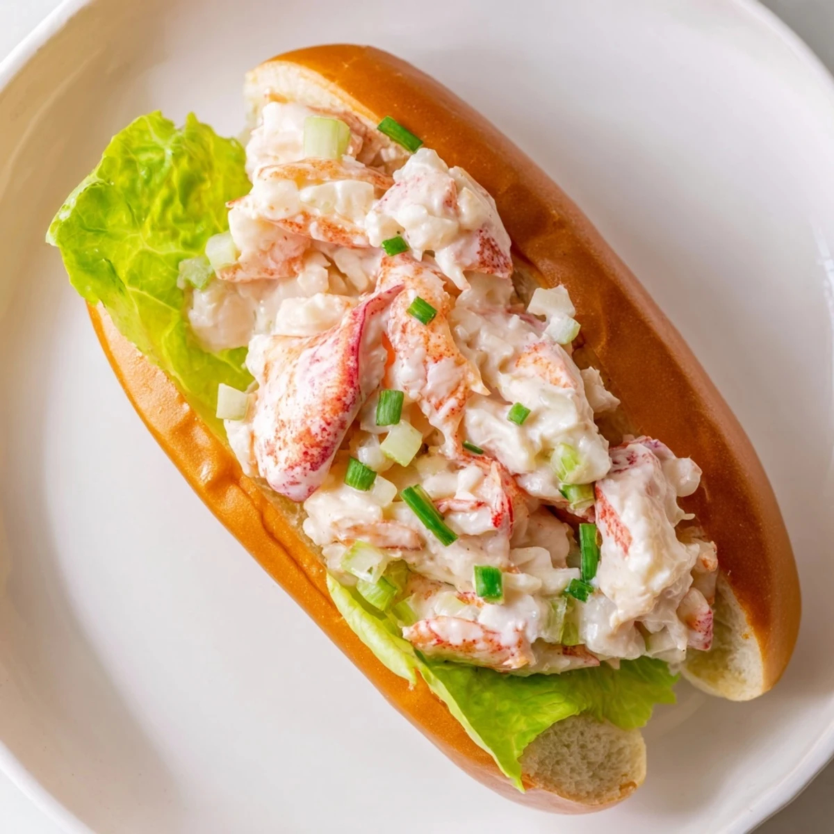 Golden toasted split-top bun overflowing with sweet Maine lobster salad and fresh chives
