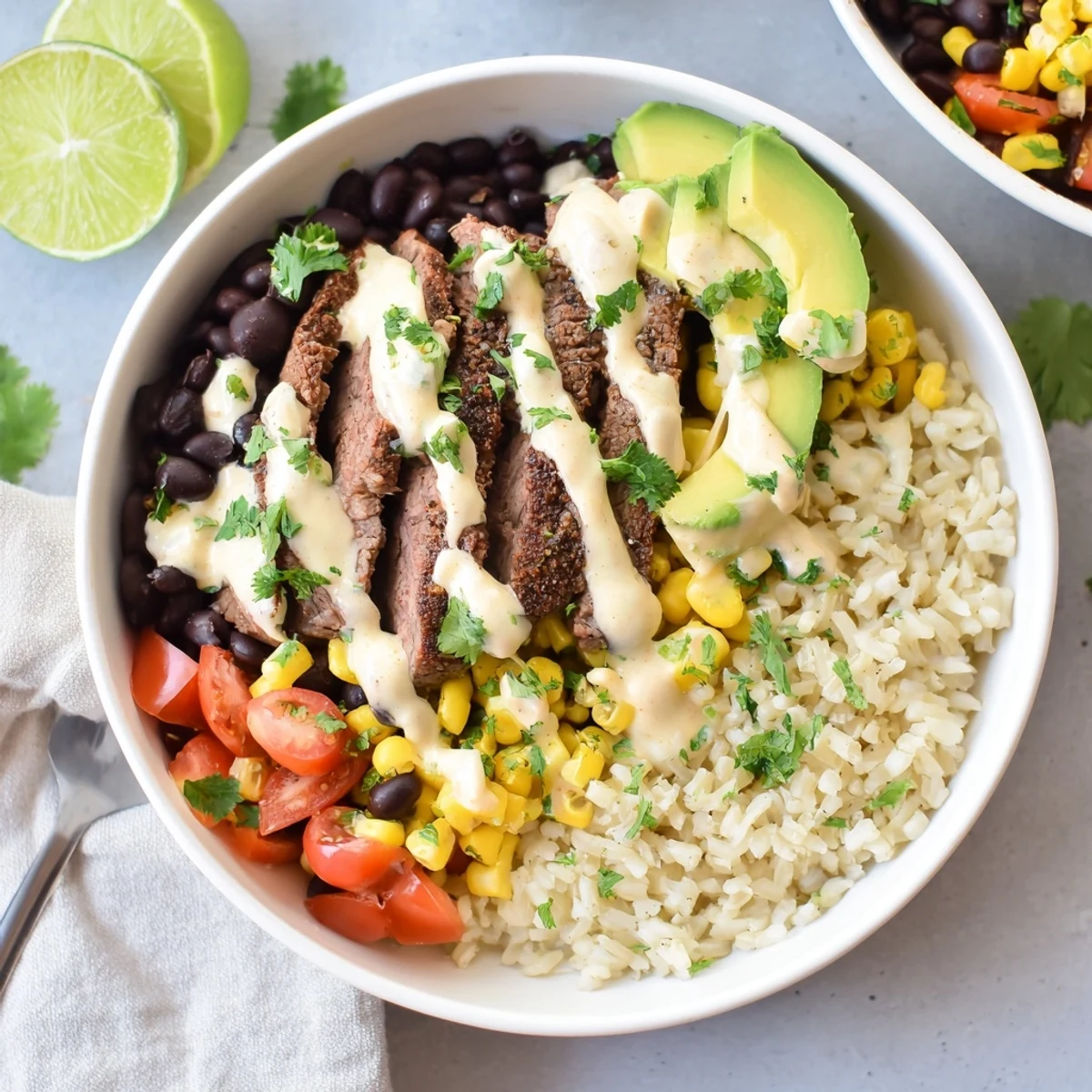 Hearty steak queso rice bowl topped with avocado, tomatoes and warm homemade queso sauce