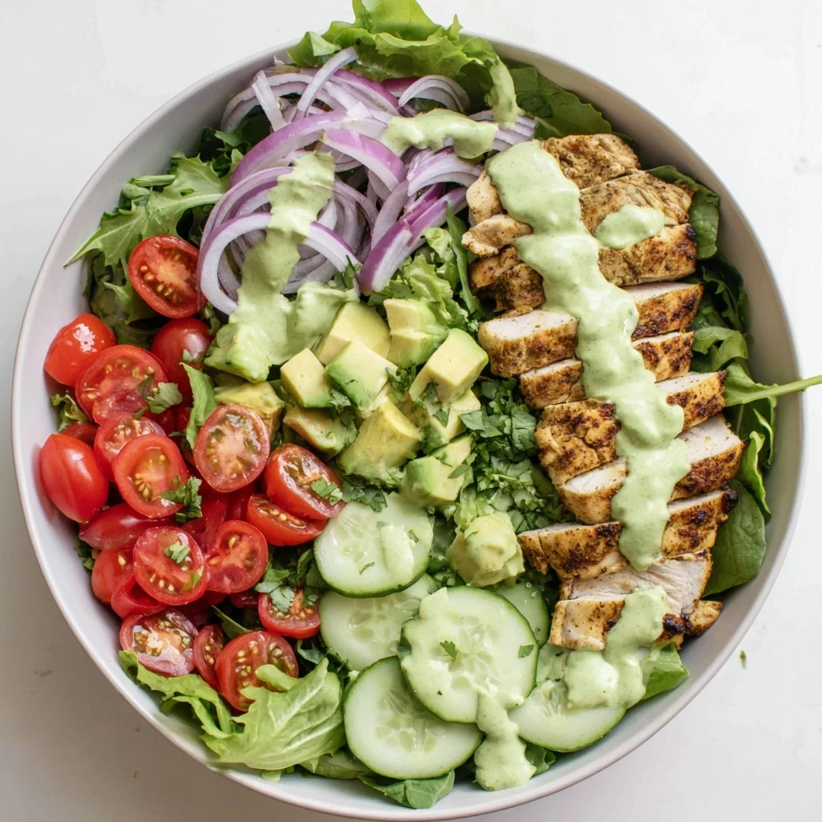 Vibrant bowl featuring juicy spiced grilled chicken with ripe avocado chunks and colorful mixed greens