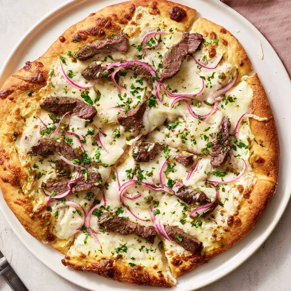 Savory beef and creamy Alfredo sauce atop crispy golden pizza crust garnished with parsley