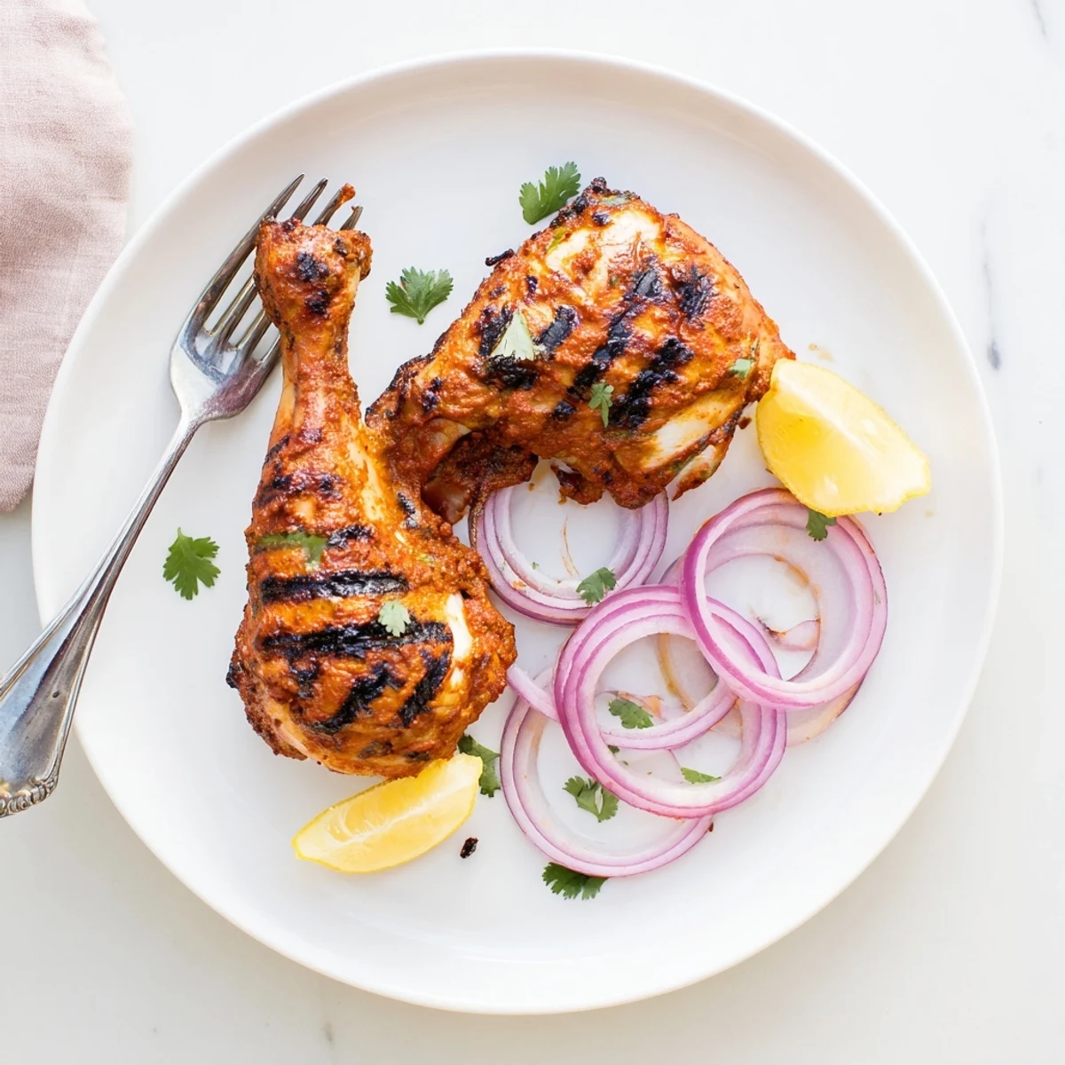 Smoky platter of Grilled Spicy Tandoori Chicken accompanied by sliced red onions