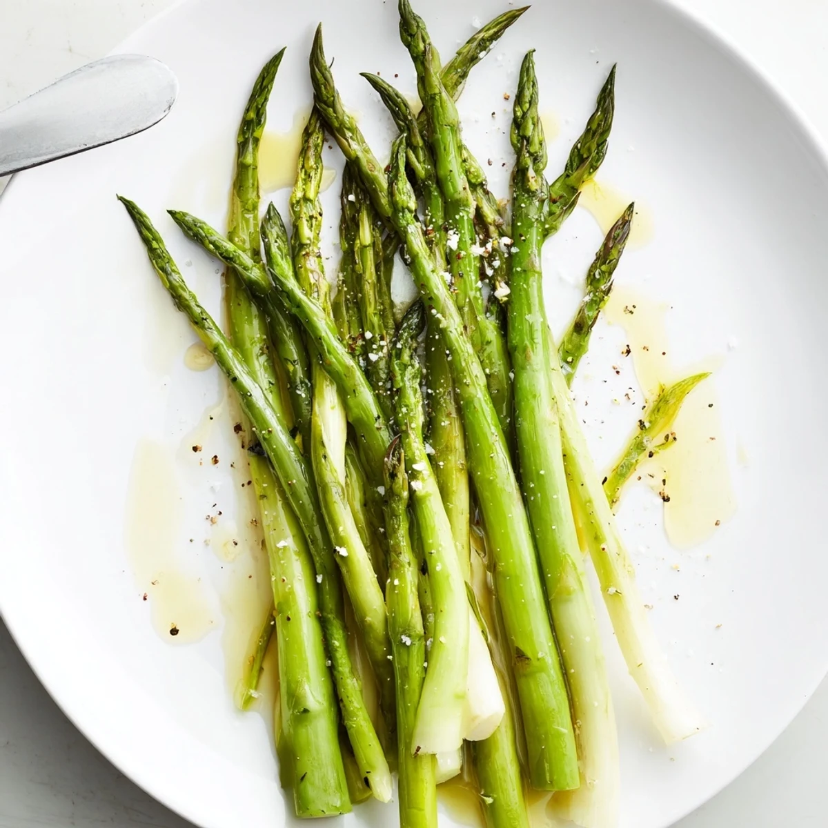Plate of Steamed Asparagus, bright green and fork tender, finished with lemon