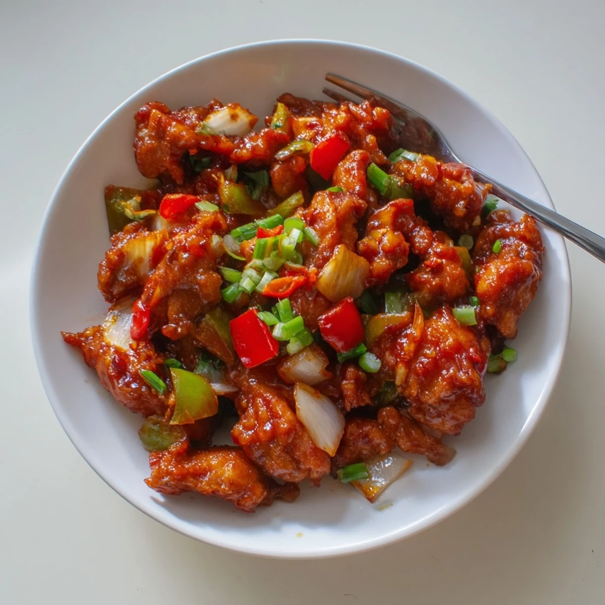 Flavorful Chilli Chicken Indo Chinese glistening in glossy sauce with scallions
