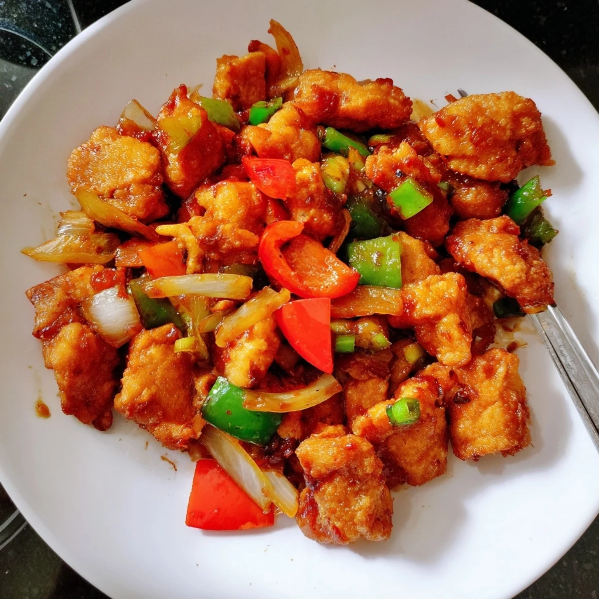 Sizzling Flavorful Chilli Chicken Indo Chinese tossed with peppers, onions, sprinkled scallions.