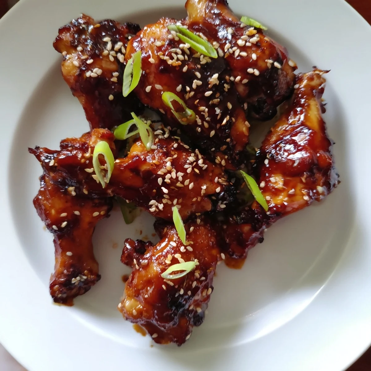 Sticky Teriyaki Baked Wings glistening with caramelized sauce, garnished with scallions