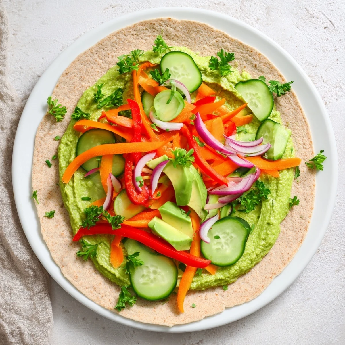 Golden whole wheat tortilla rolled with vibrant green spinach hummus and colorful fresh vegetables