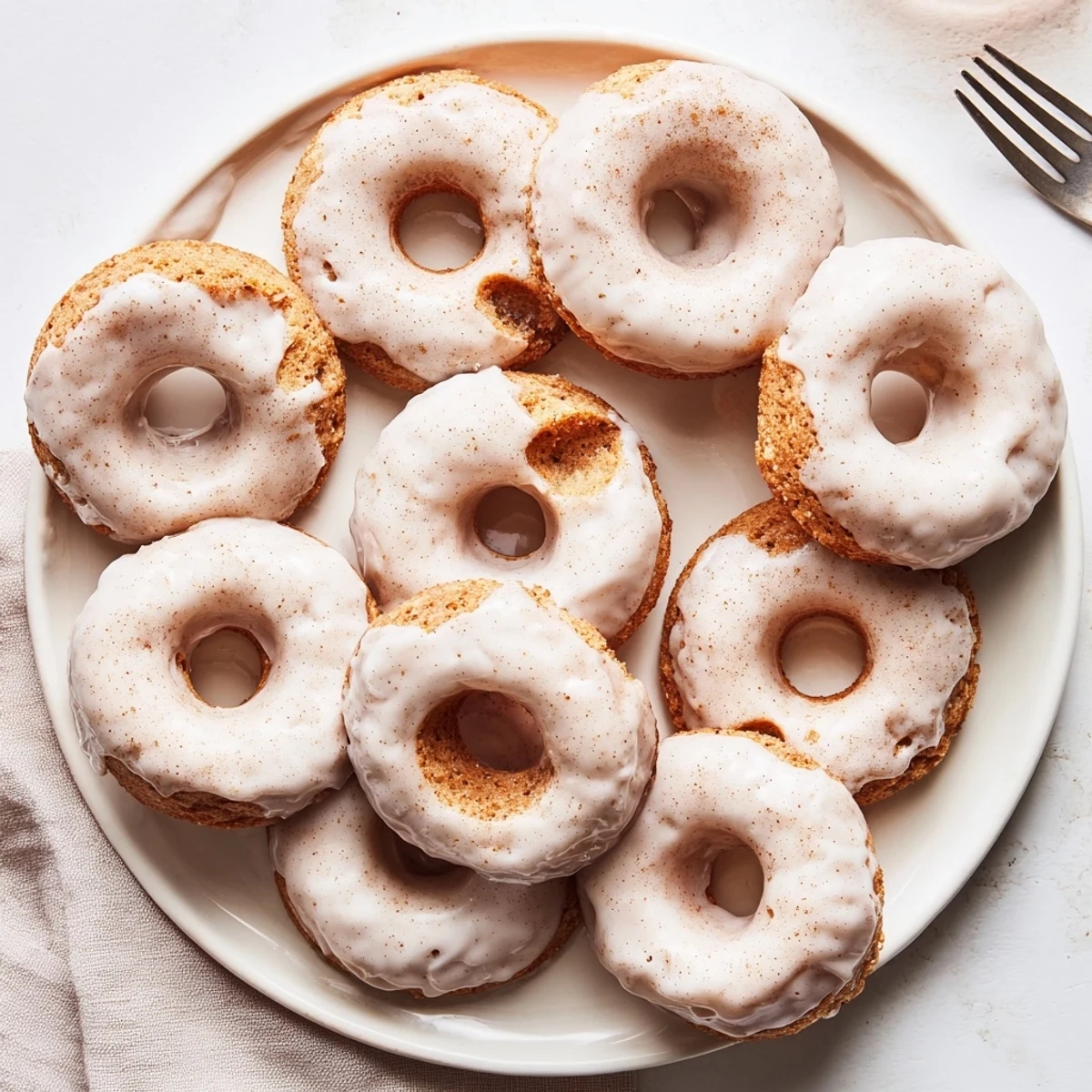 Golden brown banana bread donuts topped with sweet vanilla glaze on a wire rack