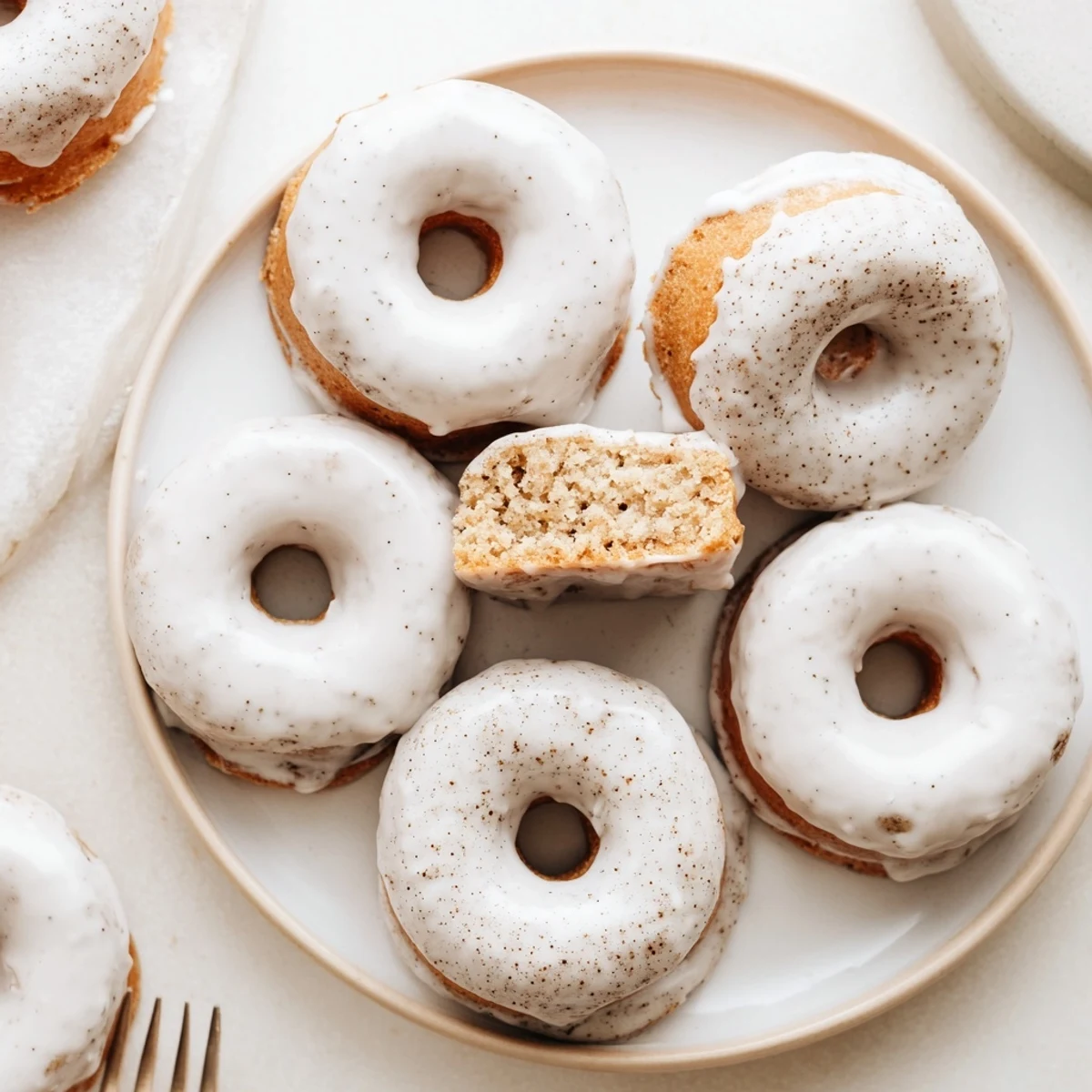 Moist baked banana bread donuts dusted with powdered sugar and warm cinnamon spice