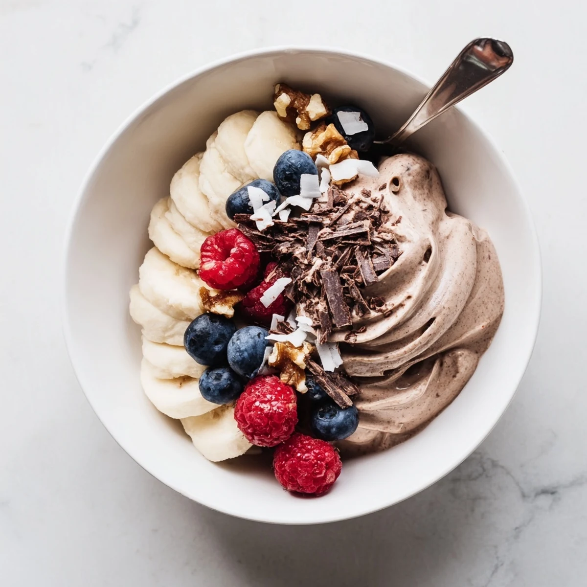Vibrant banana-based healthy nice cream recipe with smooth soft serve texture and colorful fruit garnish