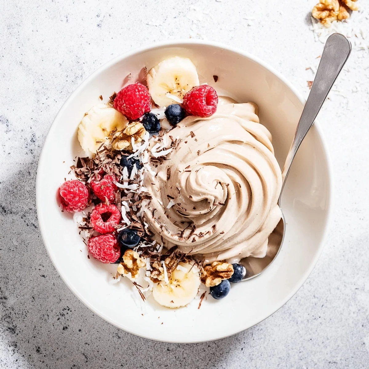 Dairy-free healthy nice cream recipe swirled with cocoa powder and topped with coconut flakes