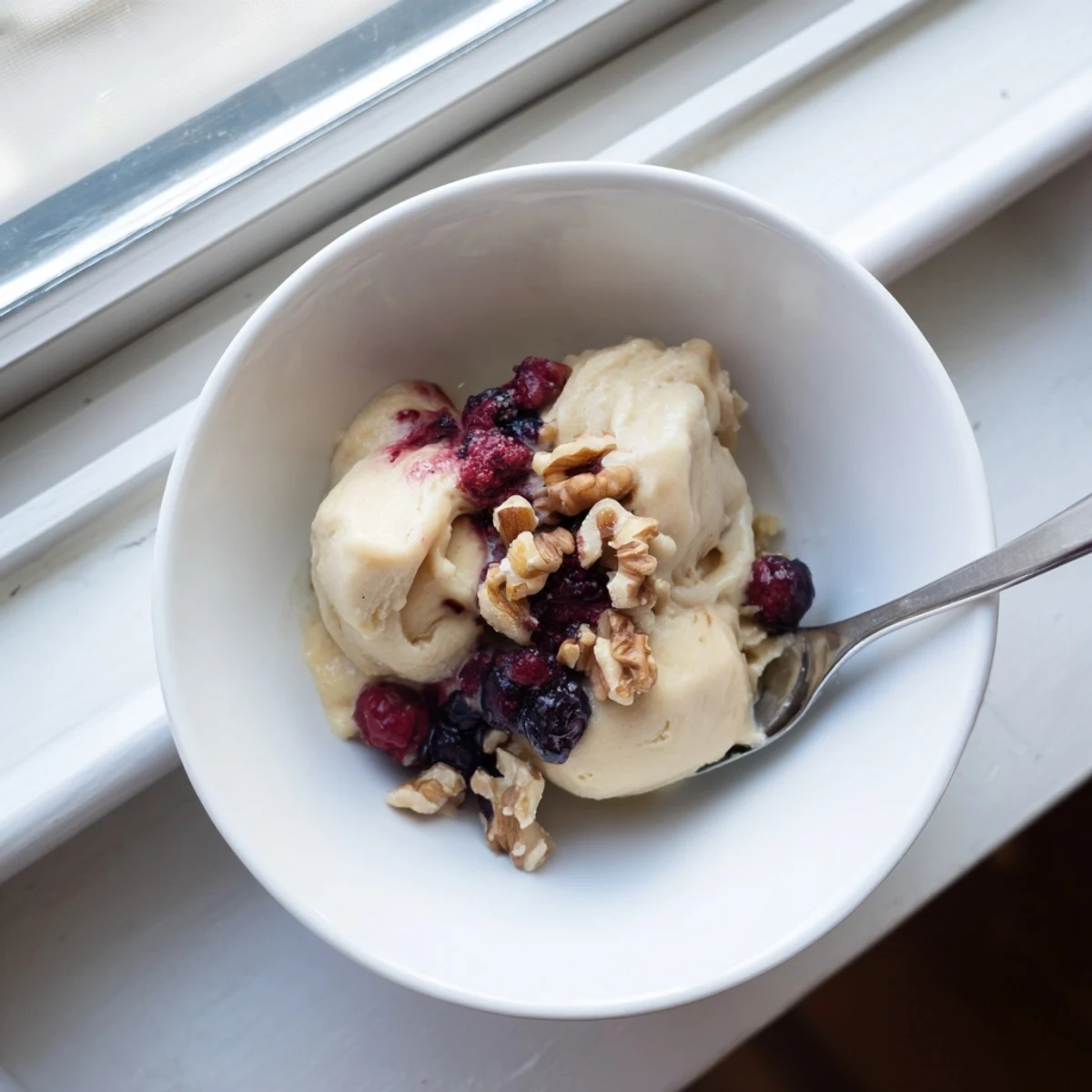 Homemade banana nice cream displaying rich consistency garnished with chocolate chips and coconut flakes