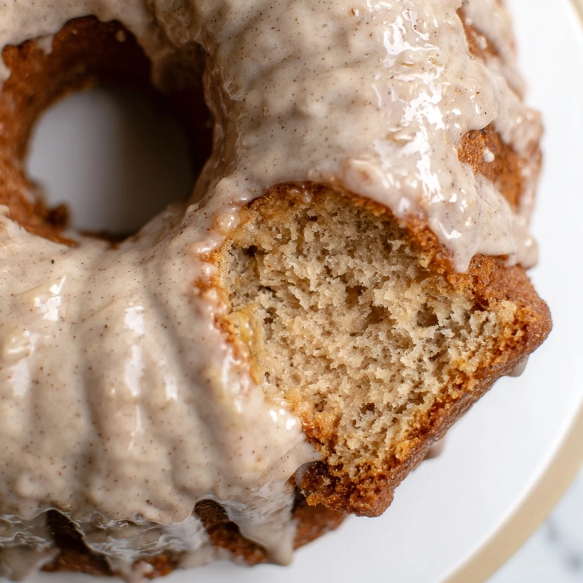 Moist banana bread donuts topped with cinnamon sugar drizzle on white plate