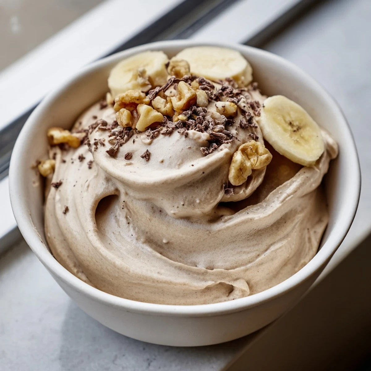 Dairy-free healthy nice cream swirling with frozen fruit in a serving bowl